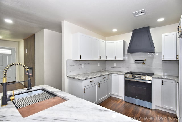 4636 E Independence St, Tulsa, OK 74115 - kitchen featuring range hood, stainless steel range with gas cooktop, dark wood-style floors, white cabinets, and recessed lighting