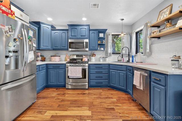 8813 E 104th Pl N, Owasso, OK 74055 - kitchen with appliances with stainless steel finishes, open shelves, blue cabinets, decorative backsplash, and recessed lighting