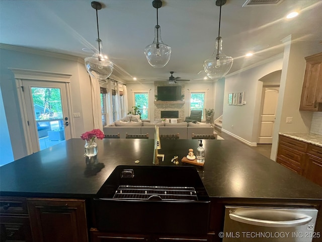 239 E 117th St S, Jenks, OK 74037 - kitchen featuring open floor plan, a ceiling fan, a center island with sink, ornamental molding, and plenty of natural light