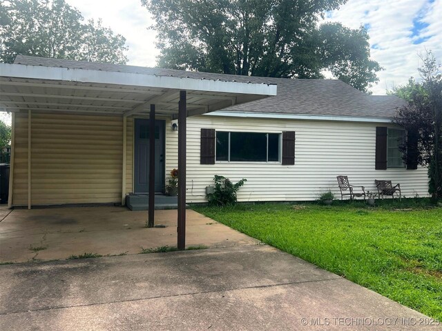 404 NE Avondale Ave, Bartlesville, OK 74006 - view of front of property featuring a front lawn, roof with shingles, and a carport
