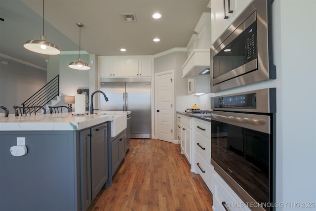 5312 E 124th Pl S, Bixby, OK 74008 - kitchen with built in appliances, crown molding, white cabinets, wood finished floors, and recessed lighting