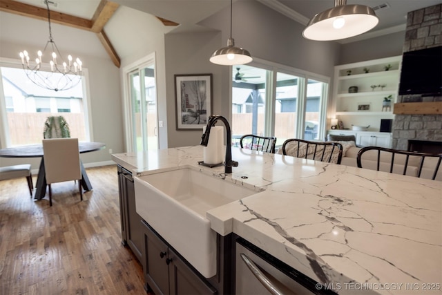 5312 E 124th Pl S, Bixby, OK 74008 - kitchen with light stone counters, a chandelier, wood finished floors, decorative light fixtures, and built in features