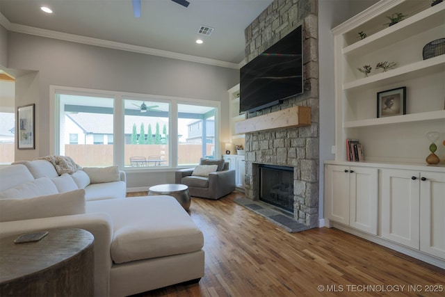 5312 E 124th Pl S, Bixby, OK 74008 - living room featuring a stone fireplace, a ceiling fan, crown molding, wood finished floors, and recessed lighting