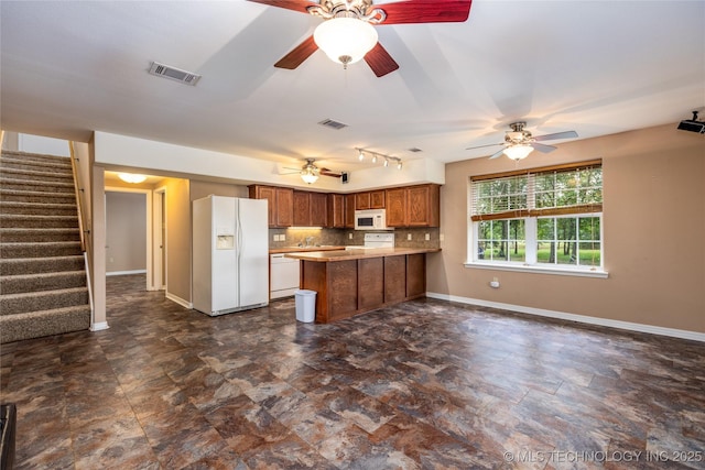 609 Lakeshore Dr, Durant, OK 74701 - kitchen with white appliances, a peninsula, brown cabinetry, and ceiling fan
