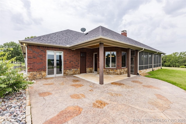 609 Lakeshore Dr, Durant, OK 74701 - back of property with a patio area, a chimney, a shingled roof, a sunroom, and stone siding