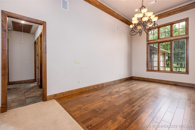 609 Lakeshore Dr, Durant, OK 74701 - empty room with a chandelier, attic access, ornamental molding, and wood finished floors
