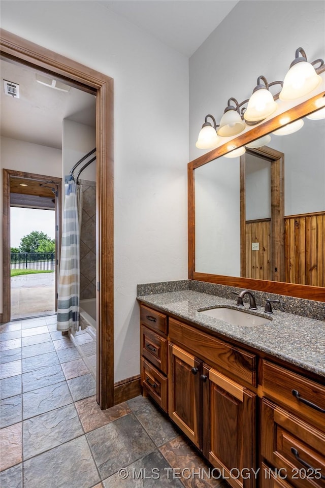 609 Lakeshore Dr, Durant, OK 74701 - bathroom with stone tile floors, vanity, and shower / bathtub combination with curtain