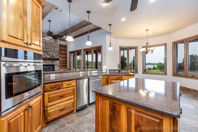 609 Lakeshore Dr, Durant, OK 74701 - kitchen featuring ceiling fan, stainless steel appliances, beam ceiling, a kitchen island, and a stone fireplace