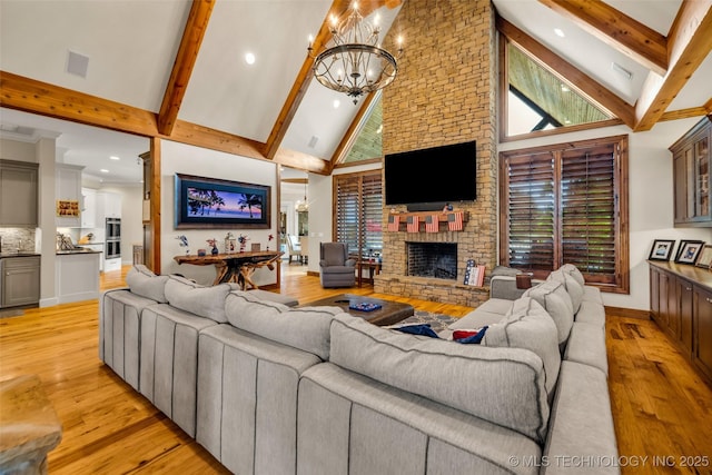 13533 S Lewis Ave, Bixby, OK 74008 - living room featuring high vaulted ceiling, a chandelier, beamed ceiling, a large fireplace, and light wood-style floors