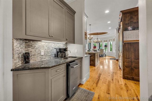13533 S Lewis Ave, Bixby, OK 74008 - kitchen with a chandelier, tasteful backsplash, light wood-style floors, recessed lighting, and dark stone counters