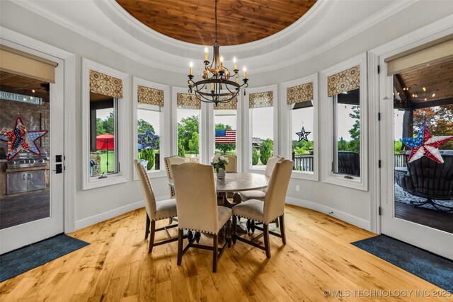 13533 S Lewis Ave, Bixby, OK 74008 - dining space featuring ornamental molding, a raised ceiling, a chandelier, and light wood finished floors