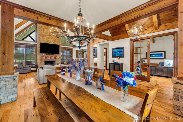 13533 S Lewis Ave, Bixby, OK 74008 - dining area with a chandelier, beamed ceiling, a fireplace, and hardwood / wood-style flooring