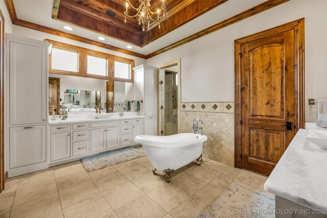13533 S Lewis Ave, Bixby, OK 74008 - bathroom with a tray ceiling, vanity, a chandelier, a freestanding bath, and tile patterned floors