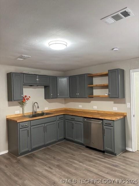 1200 S Mckinley Ave, Calera, OK 74730 - kitchen with dishwasher, butcher block counters, wood finished floors, and gray cabinetry