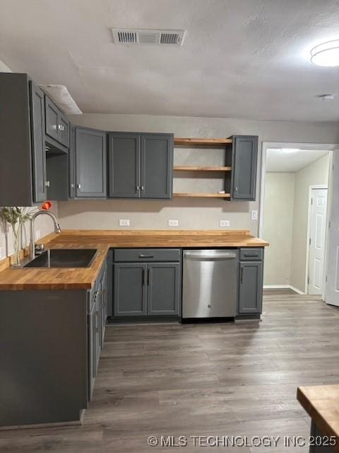 1200 S Mckinley Ave, Calera, OK 74730 - kitchen with wood counters, stainless steel dishwasher, wood finished floors, and open shelves