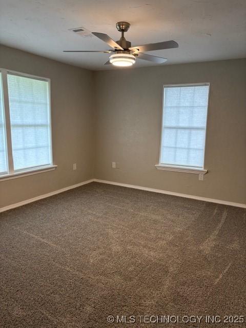 1200 S Mckinley Ave, Calera, OK 74730 - spare room with healthy amount of natural light, dark colored carpet, and ceiling fan
