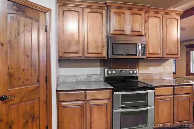 740384 S 3480th Rd, Cushing, OK 74023 - kitchen with appliances with stainless steel finishes, light stone countertops, and brown cabinets