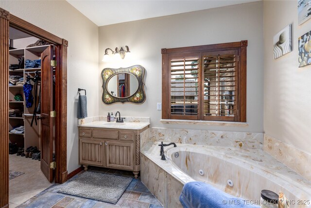 214 Kernel, Durant, OK 74701 - full bath featuring vanity, a tub with jets, a spacious closet, and stone finish flooring