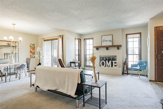 32 SE Shadowlake Dr Unit 32, Bartlesville, OK 74006 - carpeted living area with a chandelier, a large fireplace, and a textured ceiling