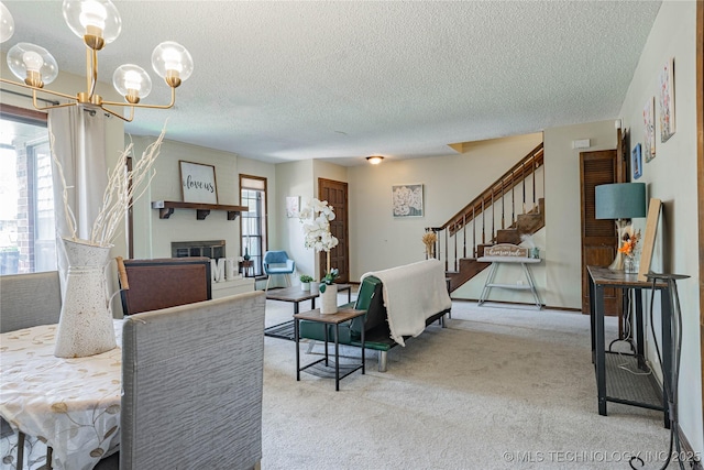 32 SE Shadowlake Dr Unit 32, Bartlesville, OK 74006 - carpeted living room with a textured ceiling, a large fireplace, stairs, and a chandelier
