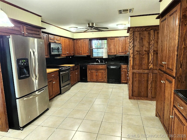 1181 Deer Crk, Pryor, OK 74361 - kitchen with stainless steel appliances, ceiling fan, light tile patterned floors, and dark countertops