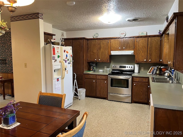 201 NE 18th Ave, Durant, OK 74701 - kitchen featuring electric stove, white refrigerator with ice dispenser, under cabinet range hood, a textured ceiling, and light countertops