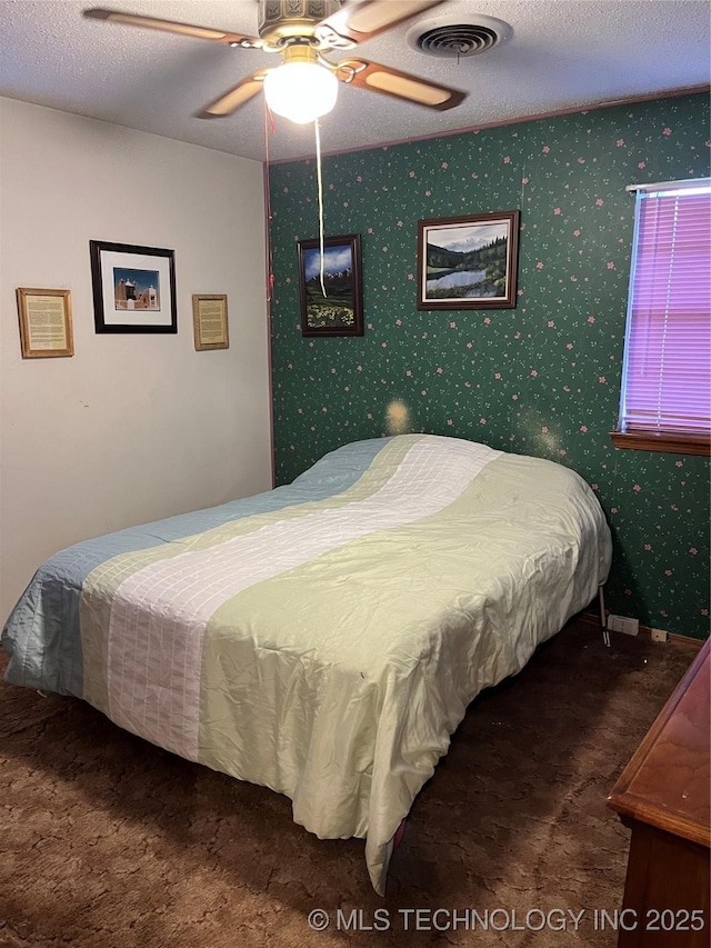 201 NE 18th Ave, Durant, OK 74701 - bedroom with carpet floors, a textured ceiling, and a ceiling fan