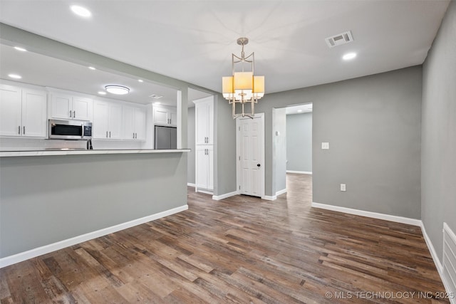 202 N Creek, Dewey, OK 74029 - kitchen featuring stainless steel microwave, fridge, white cabinetry, recessed lighting, and pendant lighting