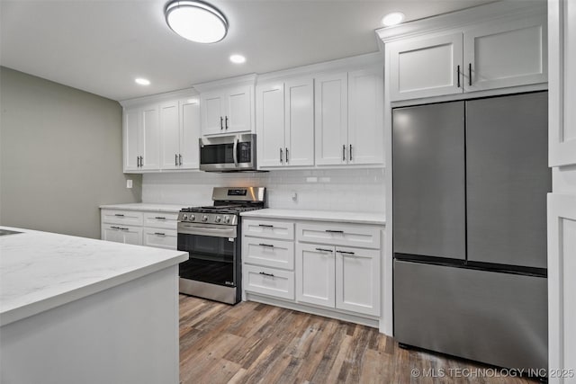202 N Creek, Dewey, OK 74029 - kitchen featuring stainless steel appliances, wood finished floors, decorative backsplash, white cabinets, and recessed lighting