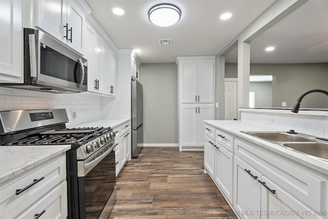 202 N Creek, Dewey, OK 74029 - kitchen featuring appliances with stainless steel finishes, backsplash, dark wood finished floors, white cabinetry, and recessed lighting