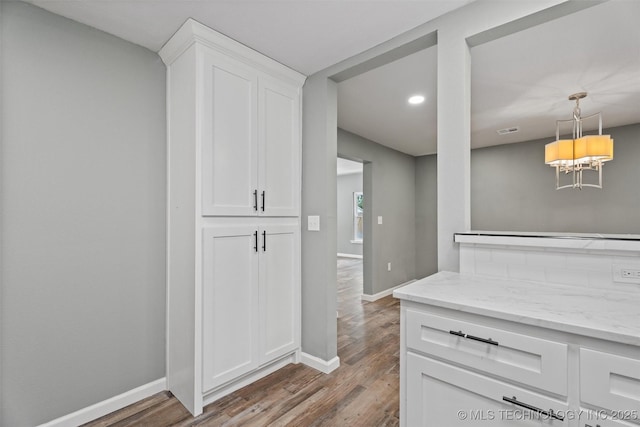 202 N Creek, Dewey, OK 74029 - kitchen with wood finished floors, white cabinets, light stone countertops, recessed lighting, and hanging light fixtures