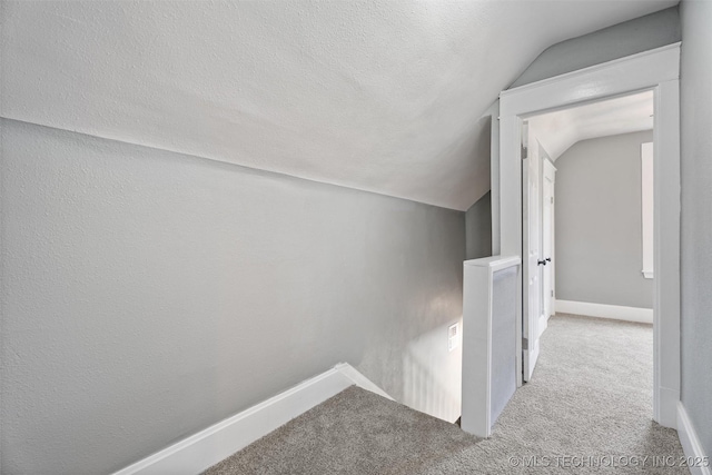 202 N Creek, Dewey, OK 74029 - hall with lofted ceiling, an upstairs landing, carpet flooring, and a textured ceiling