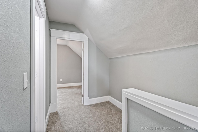 202 N Creek, Dewey, OK 74029 - hall featuring lofted ceiling, carpet floors, and a textured ceiling
