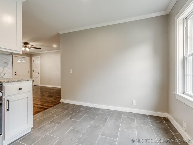 3226 N Garrison Ave, Tulsa, OK 74106 - kitchen featuring crown molding, white cabinets, ceiling fan, light stone countertops, and decorative backsplash