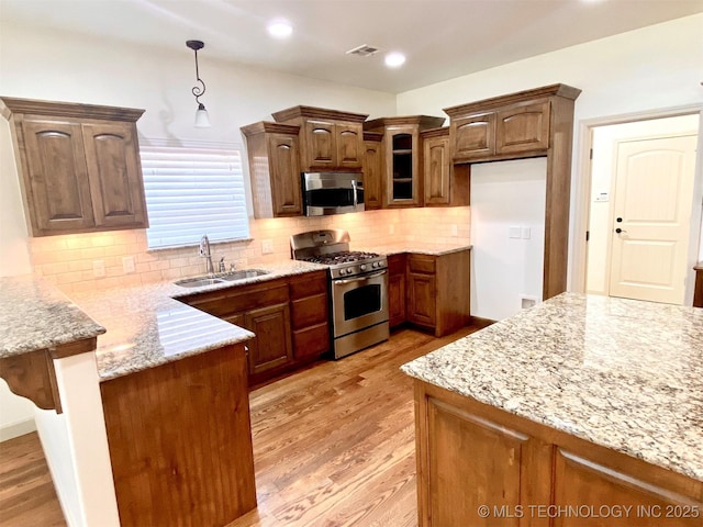 4706 S 182nd E Ave, Tulsa, OK 74134 - kitchen with appliances with stainless steel finishes, a peninsula, light wood-style floors, light stone countertops, and recessed lighting