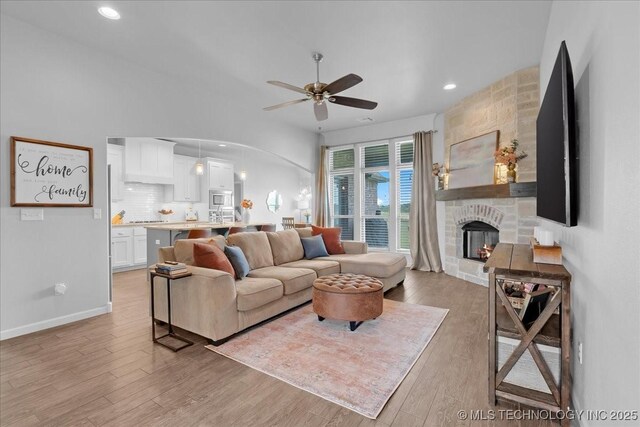 30130 S Maxine Ave, Inola, OK 74036 - living area featuring a ceiling fan, a fireplace, light wood finished floors, recessed lighting, and arched walkways