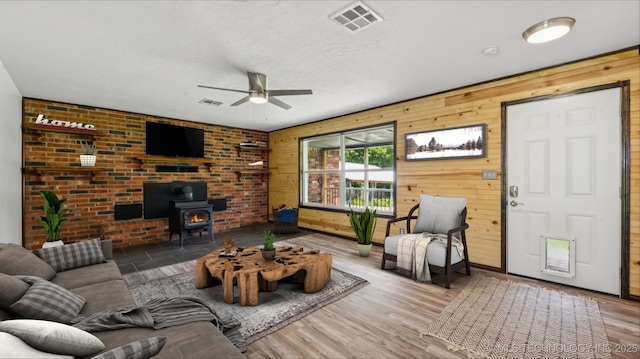 20512 E 430th Rd, Claremore, OK 74017 - living room with ceiling fan, a wood stove, wooden walls, and wood finished floors