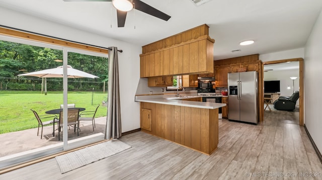 20512 E 430th Rd, Claremore, OK 74017 - kitchen with stainless steel refrigerator with ice dispenser, a peninsula, brown cabinetry, light countertops, and electric range