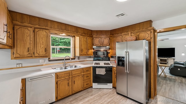 20512 E 430th Rd, Claremore, OK 74017 - kitchen featuring appliances with stainless steel finishes, under cabinet range hood, brown cabinetry, and light wood-style flooring