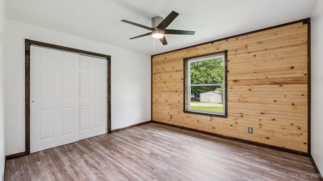 20512 E 430th Rd, Claremore, OK 74017 - unfurnished bedroom featuring wood walls, wood finished floors, a closet, and a ceiling fan