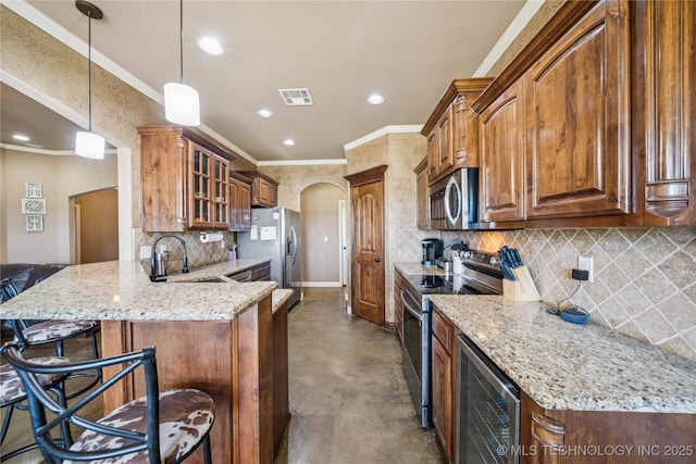 5983 E 137th St, Collinsville, OK 74021 - kitchen featuring stainless steel appliances, arched walkways, wine cooler, finished concrete flooring, and a peninsula