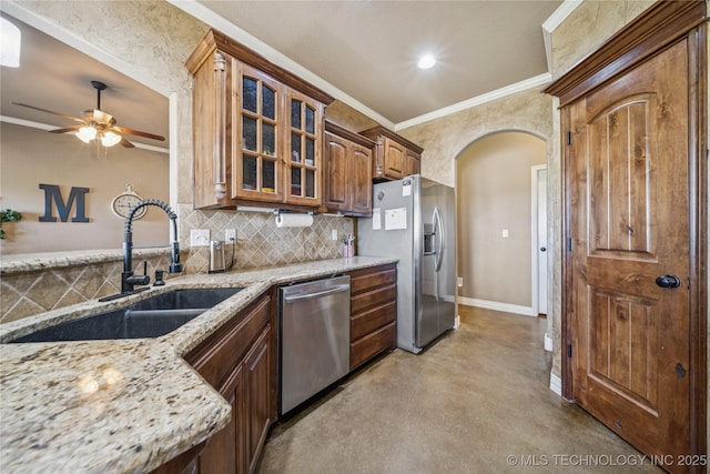 5983 E 137th St, Collinsville, OK 74021 - kitchen featuring stainless steel appliances, arched walkways, concrete floors, crown molding, and light stone countertops