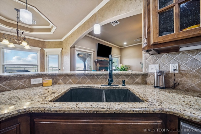5983 E 137th St, Collinsville, OK 74021 - kitchen featuring light stone countertops, glass insert cabinets, backsplash, crown molding, and hanging light fixtures