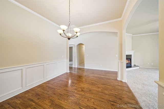 4204 N Maple Pl, Broken Arrow, OK 74012 - spare room featuring arched walkways, ornamental molding, a high end fireplace, a chandelier, and wood finished floors