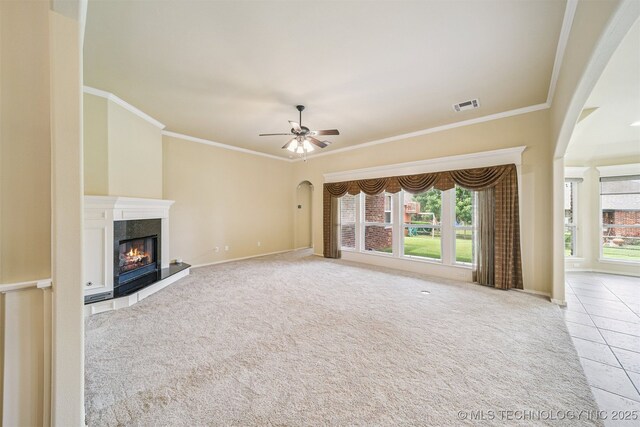 4204 N Maple Pl, Broken Arrow, OK 74012 - unfurnished living room with arched walkways, healthy amount of natural light, ornamental molding, a high end fireplace, and ceiling fan
