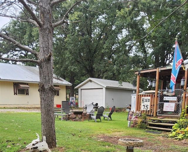 22 Quail Dr, Durant, OK 74701 - view of grassy yard with a detached garage, an outbuilding, cooling unit, and an outdoor fire pit
