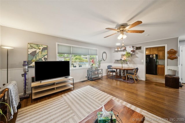 5718 E 27th St, Tulsa, OK 74114 - living area with a ceiling fan, wood finished floors, and a wainscoted wall