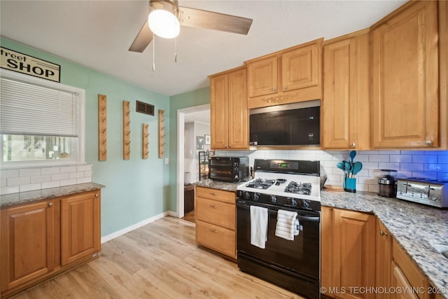 5718 E 27th St, Tulsa, OK 74114 - kitchen featuring black gas range, stainless steel microwave, tasteful backsplash, light wood finished floors, and a ceiling fan
