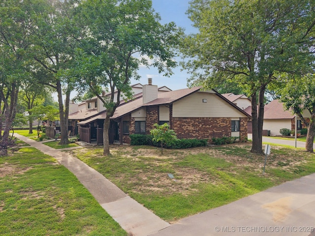 1234 S 110th E Ave Unit 59-4A, Tulsa, OK 74128 - view of side of property with brick siding, a yard, and a chimney
