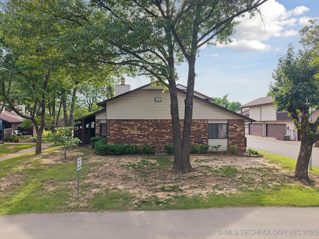 1234 S 110th E Ave Unit 59-4A, Tulsa, OK 74128 - view of home's exterior featuring brick siding and a chimney
